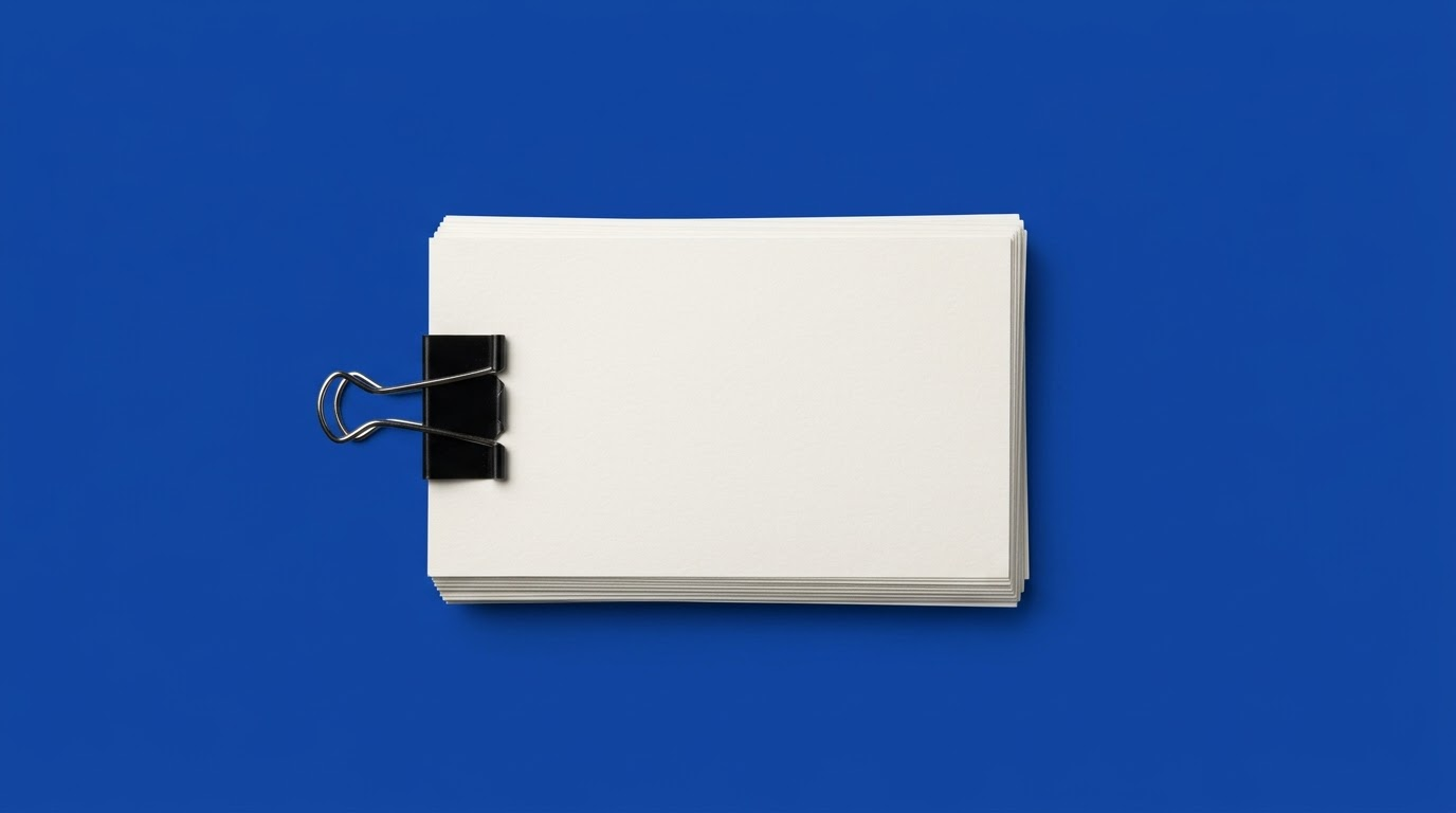 A stack of blank index cards with a binder clip, on a cobalt blue background