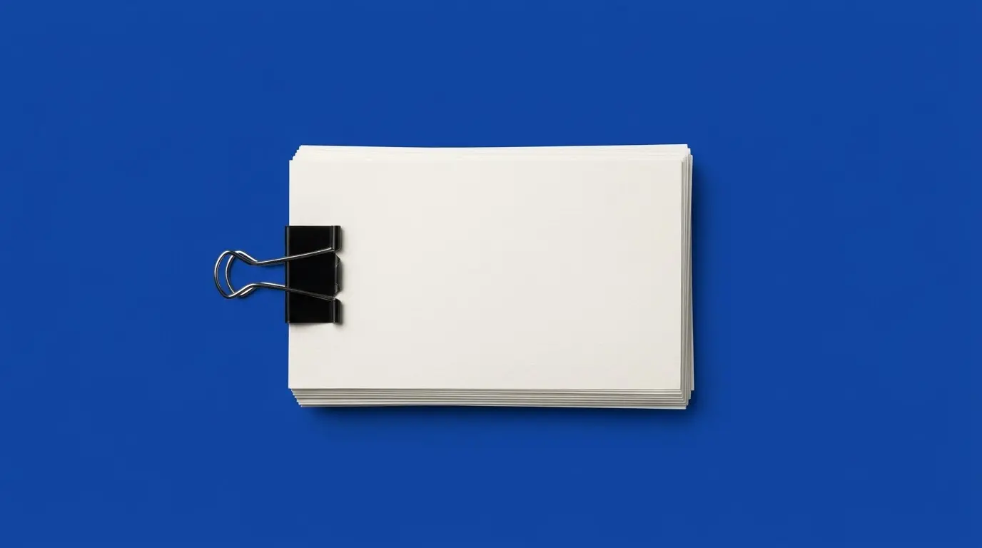 A stack of blank index cards with a binder clip, on a cobalt blue background