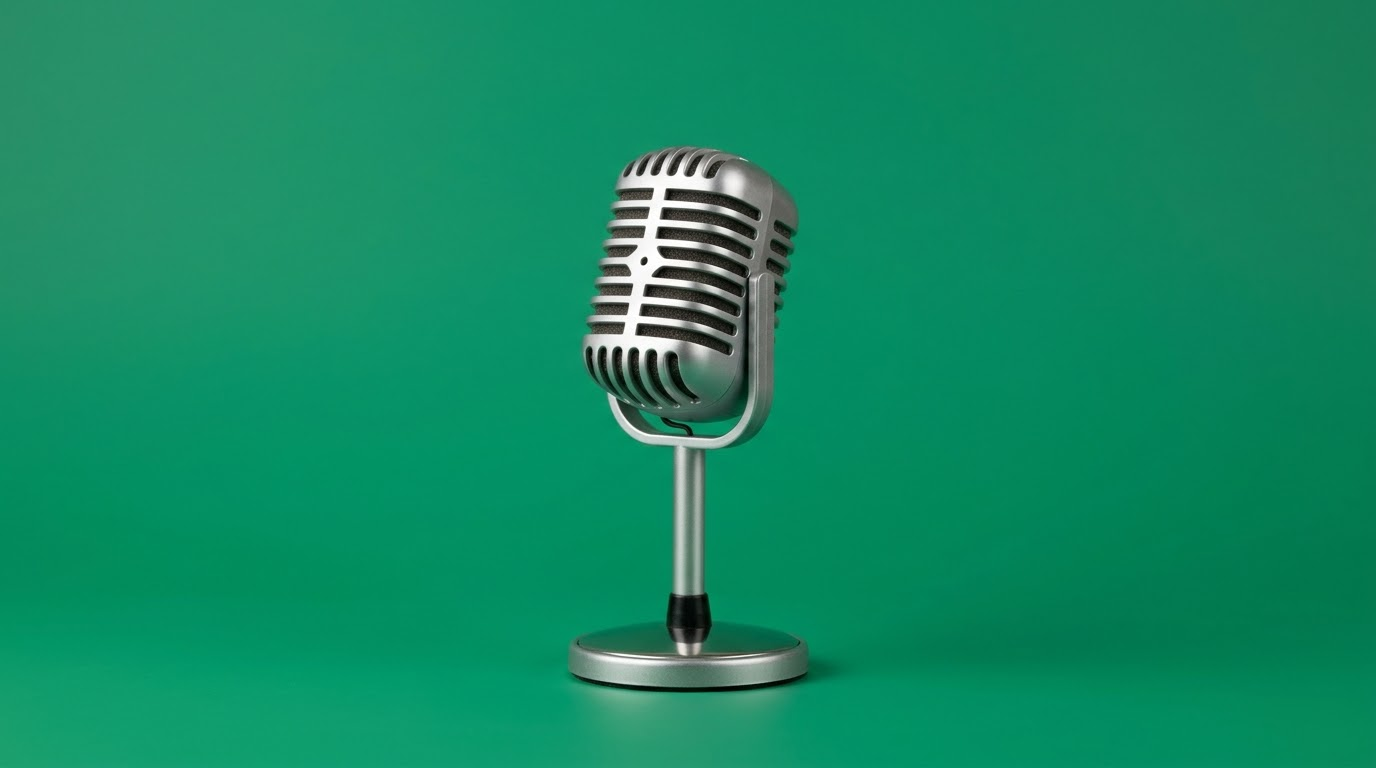 A vintage silver microphone, on an emerald green background