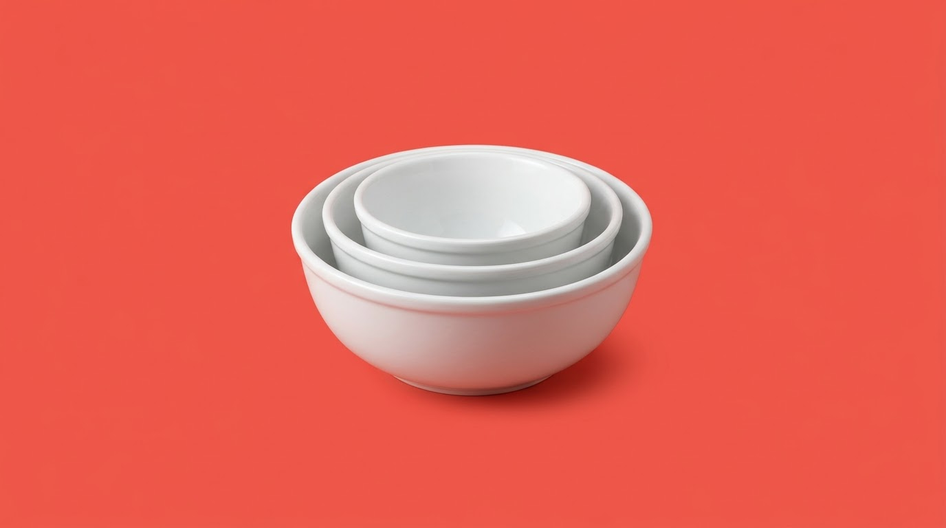 Three nested white bowls, on a coral background